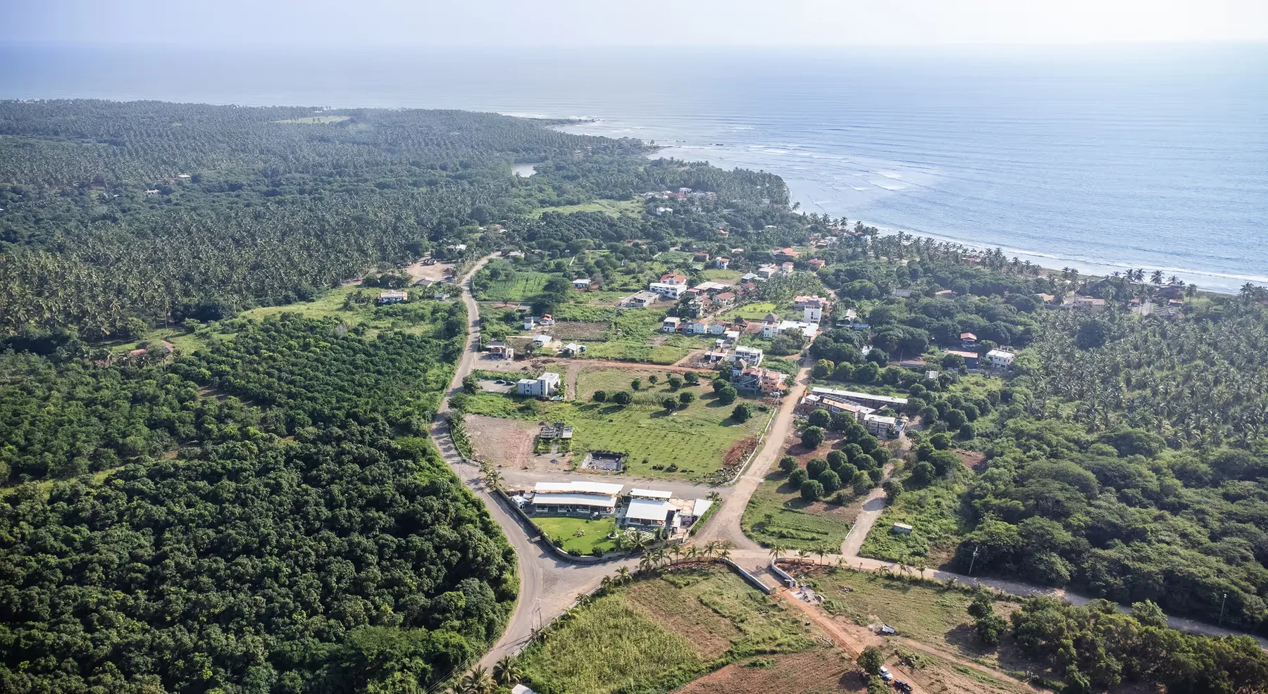Vista aérea de la plaza y del pueblo de Playa La Saladita, con el mar al fondo.